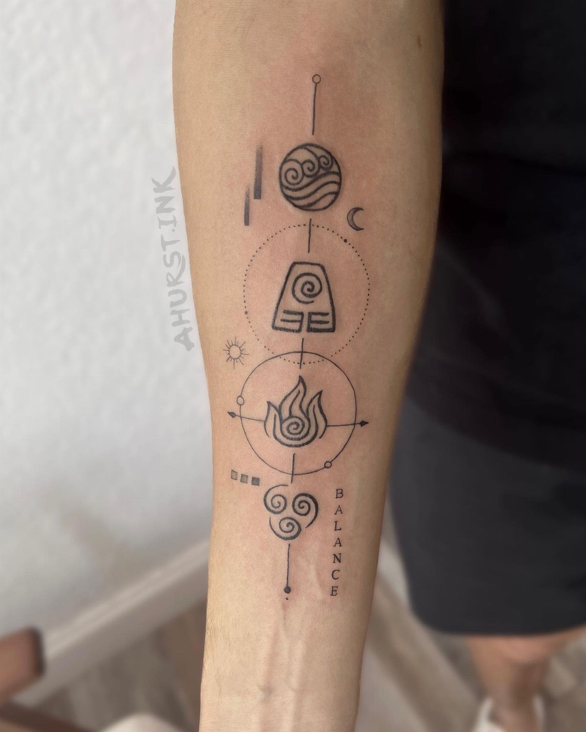 Black ink elemental symbol tattoos arranged vertically on a person's forearm with small celestial accents.